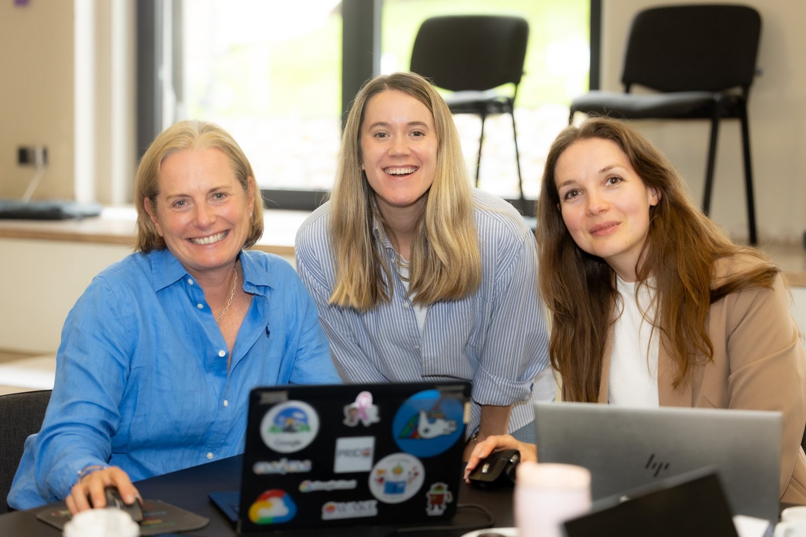 Kelly Thompson teaching hands-on at a laptop with Tech2Empower participants in Vilnius